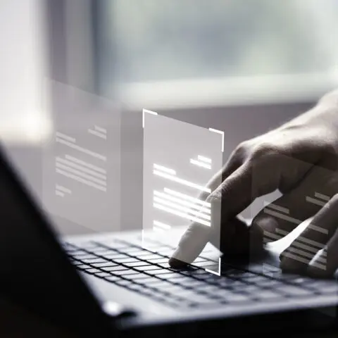 Laptop displaying ghosted document images, representing digital document security.