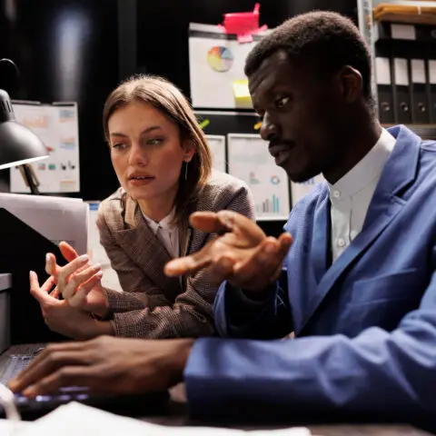 A man and woman looking at a computer screen in the wake of the Crowdstrike outage
