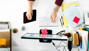 Professional multitasking with a laptop, phone, and notebook.