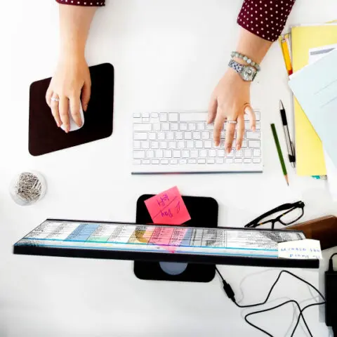 Professional multitasking with a laptop, phone, and notebook.