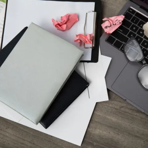 Messy desk with disorganised documents needing better management.