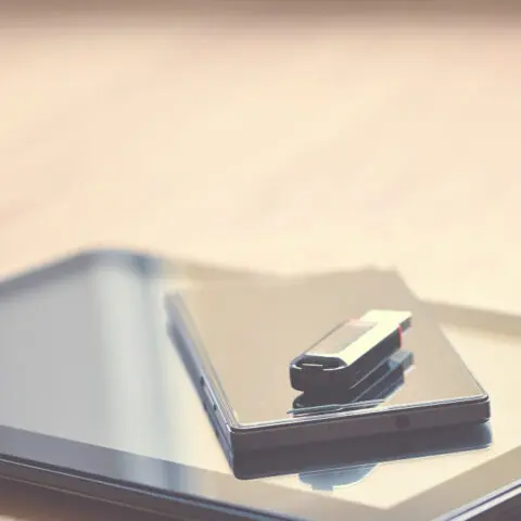 USB stick and paper with text overlay exploring photocopy definition for digital and physical documents. Short, descriptive.