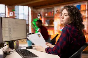 Employee uses document automation for SMEs on screen, solving worker shortage by maximising efficiency in a small business.