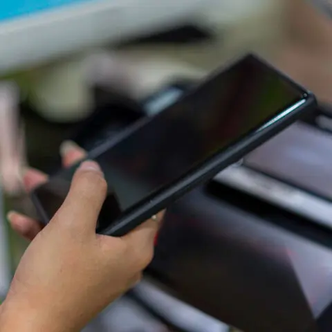 Hands printing from a smartphone using a multifunction printer's touchscreen, demonstrating effective Mobile Devices Copier Integration to maximise efficiency.