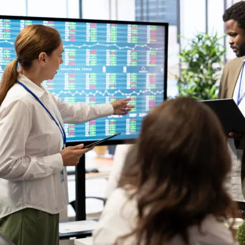 Digital Office Strategy shown by modern office with digital screens displaying growth metrics to maximise efficiency