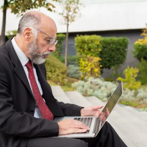 Business owner reviews automated records on a laptop to plan a tax year wealth strategy and maximise growth.