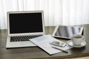 Clean desk with laptop and tablet showing paperless office benefits and an organised workspace to maximise efficiency.