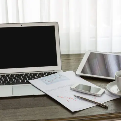 Clean desk with laptop and tablet showing paperless office benefits and an organised workspace to maximise efficiency.