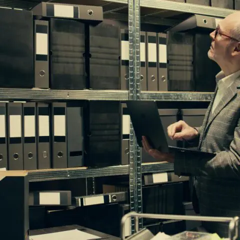 Filing cabinet being replaced by a digital workstation with AI to show digital document management benefits.