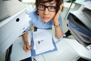 Stressed business owner with paper files by a laptop before the digital compliance deadline Lancashire.