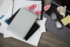 Messy desk with disorganised documents needing better management.