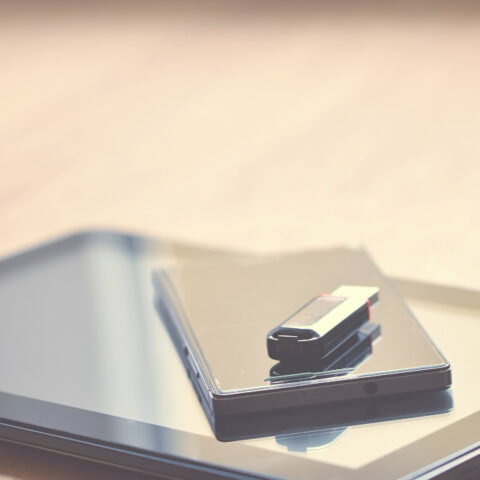 USB stick and paper with text overlay exploring photocopy definition for digital and physical documents. Short, descriptive.