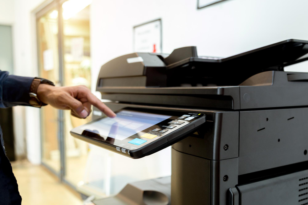 Person reviews Copier Features Checklist next to copier, highlighting key features to maximise buying decisions.