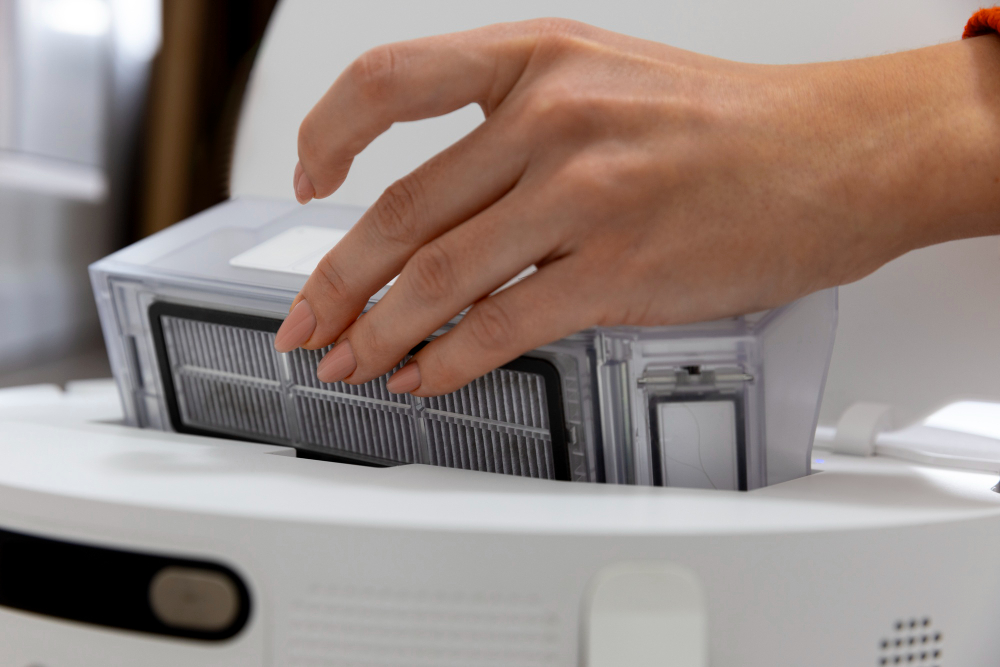 Close-up of hands performing Copier maintenance tips, cleaning paper dust to maximise machine longevity. Short, descriptive, purposeful.