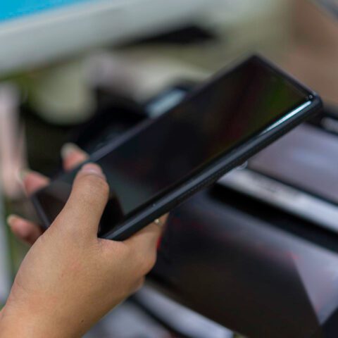 Hands printing from a smartphone using a multifunction printer's touchscreen, demonstrating effective Mobile Devices Copier Integration to maximise efficiency.
