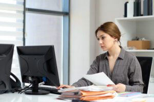 A focused office manager reviewing financial reports on a digital tablet to identify managed print service cost savings.