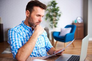 A business owner reviews office expenses on a digital tablet to understand photocopier per click charges.