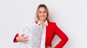An office worker looks at a stack of paper by a recycling bin, implementing sustainable office printing practices.