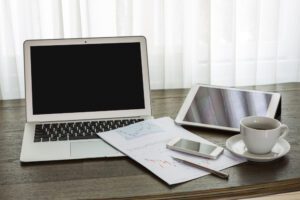 Clean desk with laptop and tablet showing paperless office benefits and an organised workspace to maximise efficiency.