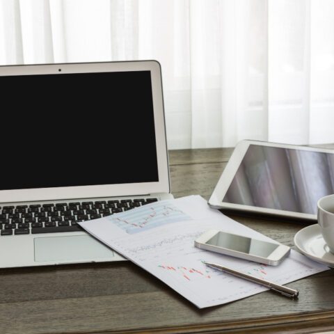 Clean desk with laptop and tablet showing paperless office benefits and an organised workspace to maximise efficiency.