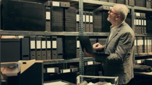 Filing cabinet being replaced by a digital workstation with AI to show digital document management benefits.