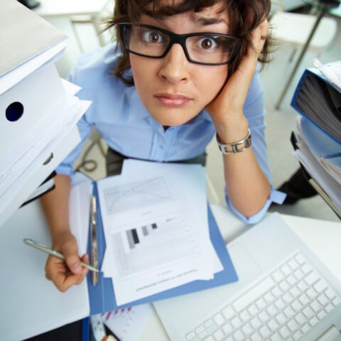 Stressed business owner with paper files by a laptop before the digital compliance deadline Lancashire.