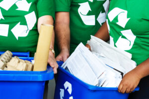 An office worker recycles paper documents in an eco-friendly workspace to support zero waste office printing UK.